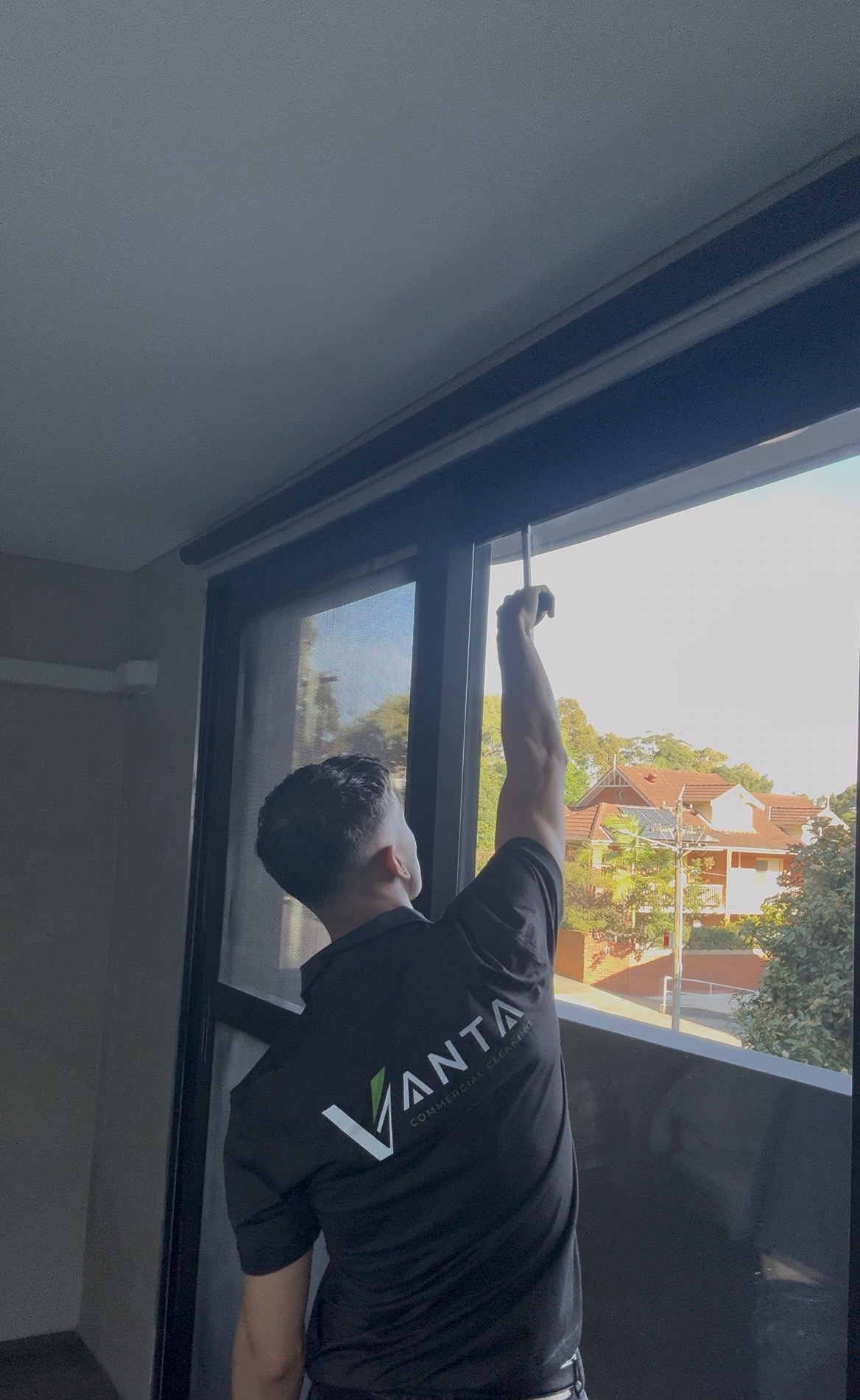 Vanta Commercial Cleaning team member cleaning a Sydney window